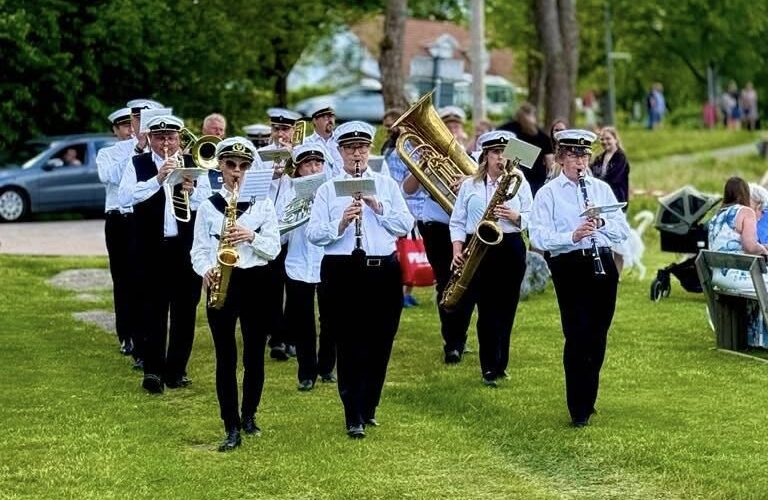 Gruvöns musikkår marscherar in till festplatsen i Liljedal midsommaren 2025